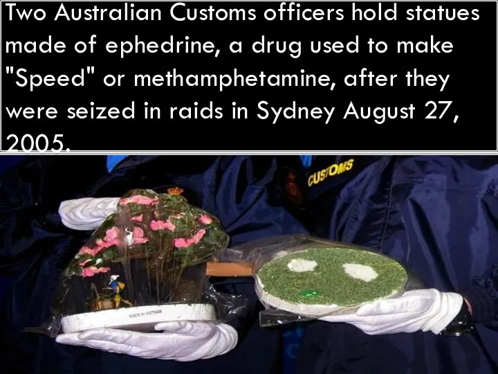 Two Australian Customs officers hold statues made of ephedrine, a drug