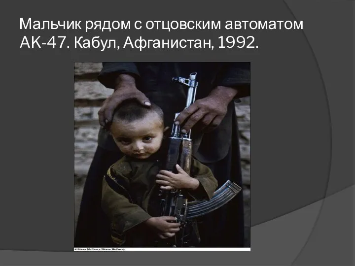 Мальчик рядом с отцовским автоматом AK-47. Кабул, Афганистан, 1992.