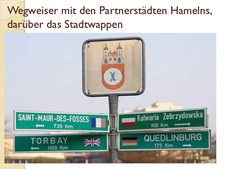 Wegweiser mit den Partnerstädten Hamelns, darüber das Stadtwappen